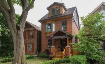  ?? RE/MAX HALLMARK REALTY LTD. PHOTOS ?? This Riverdale home has plenty of curb appeal with a red-brick exterior and a mature tree gracing the front yard.