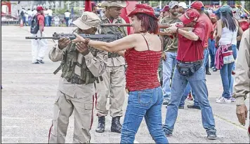  ?? AFP ?? Militiamen instruct civilians on how to use rifles during military drills in Caracas yesterday.