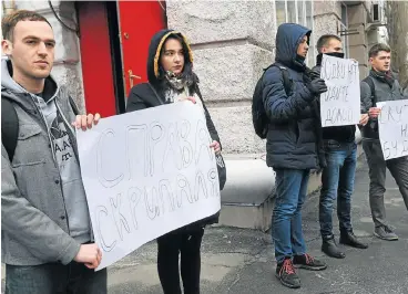  ?? /AFP Photo ?? No love lost: Activists hold placards reading ‘There is no vodka, go home’ and ‘We will not miss you’ while waiting for the Russian diplomats leaving the Russian embassy in Kiev on Wednesday.