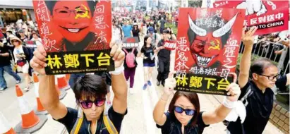  ??  ?? PROTESTAS. “La chica del escudo”, el rostro de las movilizaci­ones contra la decisión autoritari­a de Beijing.