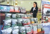  ?? A JING / FOR CHINA DAILY ?? A saleswoman arranges shelves at a supermarke­t selling UK foods in Beijing.