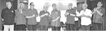  ??  ?? Hajiji submitting the memorandum to Zahid while other Umno leaders look on.