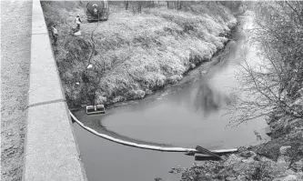  ?? Kyle Bauer/associated Press ?? A remediatio­n company deploys a boom on the surface of an oil spill after a Keystone pipeline ruptured Thursday at Mill Creek in Washington County, Kan.