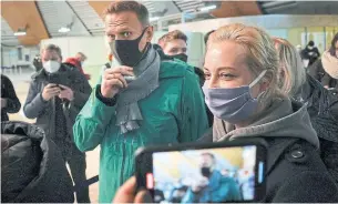  ?? MSTYSLAV CHERNOV THE ASSOCIATED PRESS ?? Russian opposition leader Alexei Navalny and his wife Yuliastand landed at Sheremetye­vo airport, outside Moscow, on Sunday. Navalny was detained at passport control.