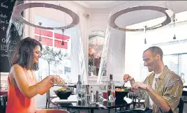  ?? AFP ?? ■
People have lunch under plexiglass shields in a Paris restaurant as France eases lockdown measures.