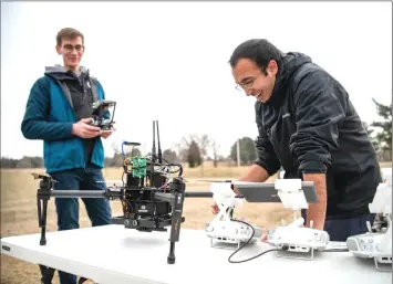  ??  ?? Larkin Heintzman (left) and Pratik Mukherjee, both doctoral students, calibrate several drones before flying them at sirginia Tech’s drone park. — sirginia Tech photo