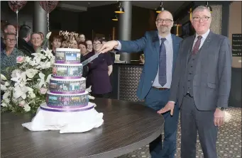  ??  ?? Colm Neville, proprietor, cutting the cake with general manager Jim Maher, to mark the 20th anniversar­y of the Riverside Park Hotel.