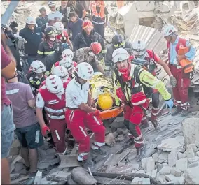  ??  ?? ALIVE: A survivor is pulled out of the rubble in the Italian town of Amatrice. Picture: Emilio Fraile