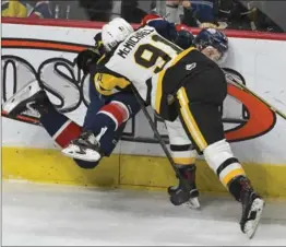  ??  ?? Hamilton Bulldogs’ Connor McMichael takes Saginaw Spirit’s Aidan Prueter into the boards.