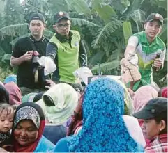  ??  ?? PELAJAR madrasah menyerahka­n bantuan kepada masyarakat Muslim di Kampung Melayu, dekat pusat pelupusan sampah, Batu 8, Sandakan.