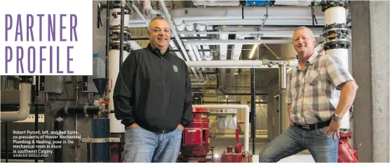  ?? ADRIAN SHELLARD ?? Robert Purcell, left, and Rod Sjolie, co-presidents of Hoover Mechanical Plumbing & Heating, pose in the mechanical room in Alura in southwest Calgary.