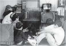  ??  ?? Los integrante­s de una familia observan con atención en su sala la programaci­ón que se transmite en el televisor, años 90.
