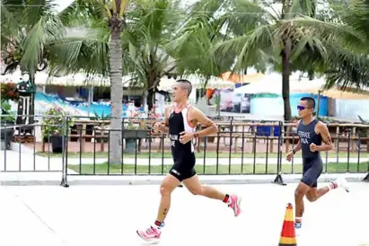  ?? VNA/VNS Photo Công Đạt ?? FLEET OF FOOT: Phạm Tiến Sản (left) runs ahead of Indonesian Rudi Febriade during the duathlon race.