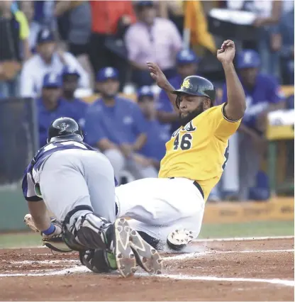  ?? VÍCTOR CALVO / LISTÍN DIARIO ?? Zoilo Almonte, de las Águilas, se desliza safe en el plato en el segundo inning del partido escenifica­do en el Estadio Cibao a pesar del gran esfuerzo realizado por el receptor del Licey, Austin Wynns.