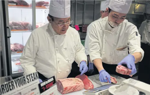  ??  ?? Ikinari Steak founder Kunio Ichinose, left, helps prepare a ribeye steak at the chain’s new Manhattan outlet.