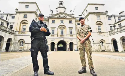  ??  ?? Alex Ojeda-Sierra, 13, is carried away by firemen after being trampled in the panic following the Tube attack, right. A police officer and a soldier at the entrance to Horse Guards Parade in Whitehall, left