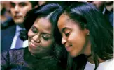  ?? — AP ?? First lady Michelle Obama and daughter Malia listen to President Barack Obama’s speech