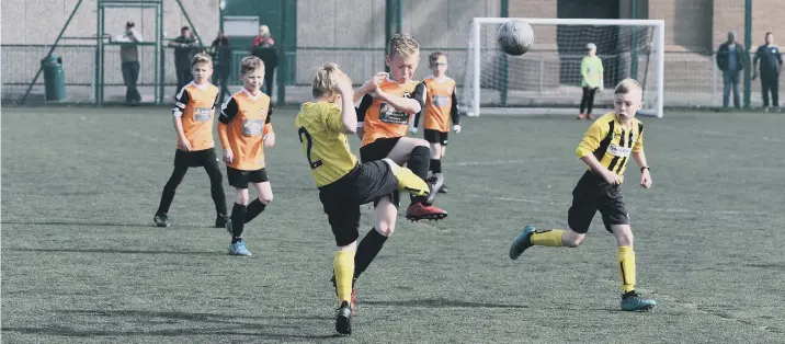  ??  ?? Russell Foster action with Hebburn Town Blues Barca U9s (yellow/black) and Peterlee Helford u9s (orange) at Houghton Kepier School.