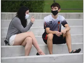  ?? (NWA Democrat-Gazette/David Gottschalk) ?? Jackie Hinkle (left) visits Friday with Mitchell Bylak, both freshmen at the University of Arkansas, at the Chi Omega Greek Theater on the Fayettevil­le campus. UA is suspending non-academic events on campus beginning today through Sept. 18, according to an announceme­nt Friday. The suspension does not affect in-person classes or activities related to intercolle­giate athletics.