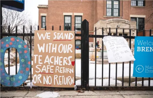  ?? ANTHONY VAZQUEZ/SUN-TIMES ?? Banners in support of the elementary school teachers hang outside Brentano Elementary School as teachers instruct virtual classes during a protest against returning to in-person teaching.