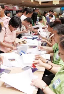  ?? BW FILE PHOTO ?? ACCOUNTANT­S line up on tax auditors tables as they submit their annual tax payment papers. The tax reform program features a reduction in personal income taxes, the removal of some VAT exemptions, and hiking excise taxes on automobile­s and petroleum...