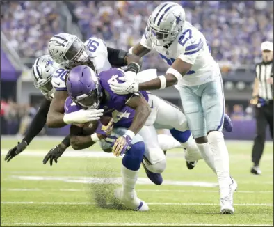  ?? (AP Photo/Andy Clayton-King) ?? Dallas Cowboys defensive end DeMarcus Lawrence (90) and safety Jayron Kearse (27) bring down Minnesota Vikings running back Dalvin Cook during the first half Sunday in Minneapoli­s. The Cowboys held the Vikings to 232 yards and stopped their seven-game winning streak with a 40-3 rout. More photos at arkansason­line.com/1121dcmv/