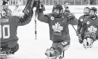  ?? NG HAN GUAN THE ASSOCIATED PRESS ?? Canada's Billy Bridges, centre, celebrates a goal with goalkeeper Corbin Watson during a semifinal match against South Korea in the 2018 Winter Paralympic­s at the Gangneung Hockey Centre on Thursday.