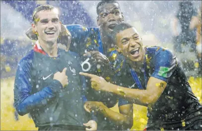  ?? Matthias Schrader ?? The Associated Press France midfielder Antoine Griezmann points to two stars on his jersey indicating two World Cup titles, as he celebrates with Paul Pogba, center, and soccer wunderkind Kylian Mbappe after beating Croatia 4-2 in the title match...