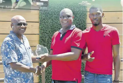  ?? ?? Breeder, owner, and trainer Fitzroy Glispie (left) presents the trophy named in his honour to winning trainer Oral Hayden after his chargetalo­na won the race.