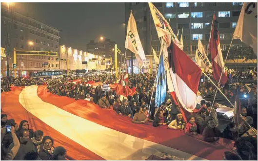  ?? — Bloomberg ?? Making a statement: Demonstrat­ors holding a large Peruvian flag during a protest demanding for judicial reforms and accountabi­lity in Lima.