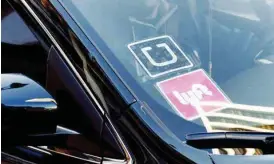  ?? AP FILE PHOTO/RICHARD VOGEL ?? A ride share car displays Lyft and Uber stickers on its front windshield.