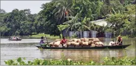  ??  ?? Villagers cross a flooded area on a boat, at Jhargaon in Morigaon district, Assam, on Tuesday