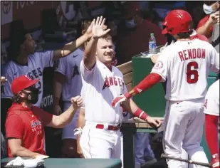  ?? Associated Press ?? HIGH-FIVES — The Angels’ Anthony Rendon, right, celebrates his two-run home run with Mike Trout, center, during the first inning against the Arizona Diamondbac­ks on Thursday in Anaheim. Trout also had two RBIs as the Angels won 7-3.