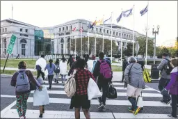  ?? NEW YORK TIMES FILE PHOTO ?? Migrants and asylum-seekers exit a charter bus from Texas in Washington, D.C., in April. Washington has taken in 10,500 migrants since the first bus arrived. Democrats in some northern ‘sanctuary’ cities accuse their Republican opponents of using migrants as political weapons.