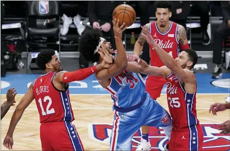  ?? FRANK FRANKLIN II — THE ASSOCIATED PRESS ?? Brooklyn’s Jarrett Allen, center, shoots between Philadelph­ia 76ers’ Ben Simmons, right, and Tobias Harris, left, in the second half during the second half of the Nets 122-109 victory Thursday night at the Barclays Center.