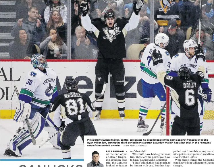  ?? — THE ASSOCIATED PRESS ?? Pittsburgh’s Evgeni Malkin, centre, celebrates his second goal of the game against Vancouver goalie Ryan Miller, left, during the third period in Pittsburgh Saturday. Malkin had a hat trick in the Penguins’ come-from-behind 5-4 win.