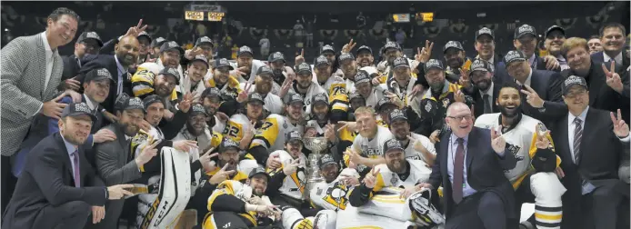  ?? - Associated Press: Mark Humphrey ?? Les membres des Penguins de Pittsburgh ont posé pour la traditionn­elle photo autour de la coupe Stanley.