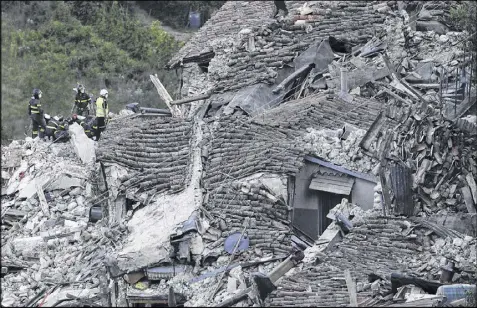  ?? GREGORIO BORGIA / AP ?? Rescuers search through rubble of collapsed houses following an earthquake in Pescara Del Tronto, Italy, Wednesday. Dozens of people were pulled from the debris by rescue teams and volunteers that poured in from around Italy, but the toll was expected...