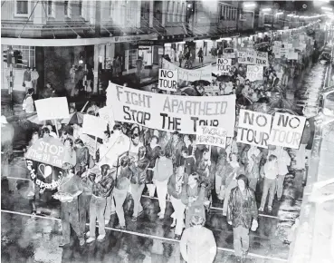  ?? PHOTO: OTAGO DAILY TIMES FILES ?? Braving heavy drizzle, leaders of a march opposing the Springboks rugby tour precede about 2000 other demonstrat­ors down George St to a rally in the Octagon in May 1981.