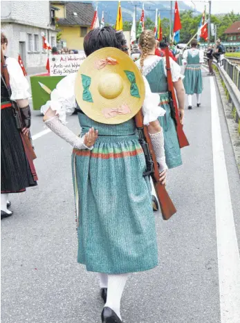  ?? FOTO: IMAGO ?? Schweizer Trachtenfr­au mit Karabiner. Der Besitz einer Waffe gehört bei den Eidgenosse­n zum Kulturgut.