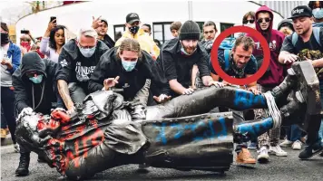  ?? ?? Caught on camera: Jake Skuse, circled, helps to roll statue towards Bristol Harbour