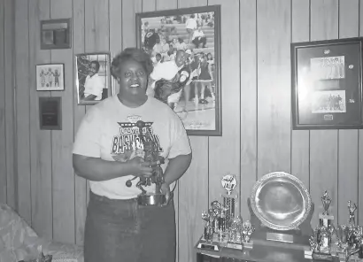  ?? TONY KRAUSZ/AP ?? Lusia Harris Stewart shows off some of her medals and awards from her basketball career. Harris was the only woman to be drafted by an NBA team and scored the first points in women’s basketball history at the Olympics.