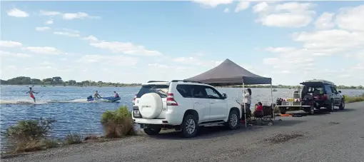  ??  ?? SHOT LEFT. The Strauss family, next to the tar road to Nata. “The road was underwater for up to a kilometre in places, so traffic wasn’t a problem,” says Richardt Strauss. “Motorboats aren’t allowed on dams in Botswana so when it rains we ski on any puddle we can find!”