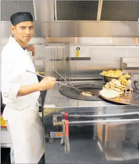  ??  ?? Little India chef Harish Singh cooks in the tandoor oven.