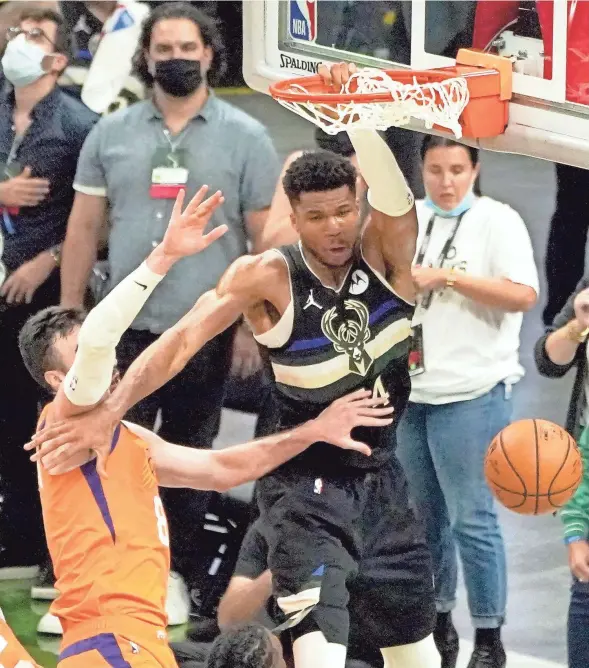  ?? MIKE DE SISTI/MILWAUKEE JOURNAL SENTINEL ?? Bucks forward Giannis Antetokoun­mpo dunks over Suns forward Frank Kaminsky during the fourth quarter of Game 6 .