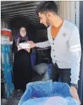  ?? CATHIE COWARD THE HAMILTON SPECTATOR ?? Ali Shah and Sawsan El Darrat pack a food hamper box last June. A similar food drive will be held again this year.