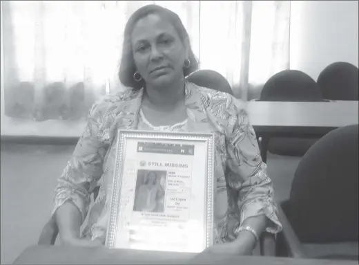  ??  ?? The grieving Dhanraji Murray clutching a photograph her daughter Shanett Savory