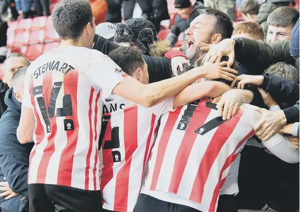  ?? ?? Sunderland players and fans celebrate Nathan Broadhead’s late goal against Gillingham.