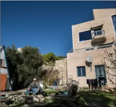  ??  ?? In this 2016 file photo, Moshe Gordon sits outside his guest house advertised on the Airbnb internatio­nal home-sharing site, in the Nofei Prat settlement in the West Bank. AP Photo/tsAfrIr AbAyoV