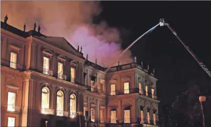  ??  ?? In flames: The fire that engulfed the 200-year-old National Museum in Rio de Janeiro is symbolic of the state of political and economic disarray in Brazil. Photo: Carl De Souza/AFP